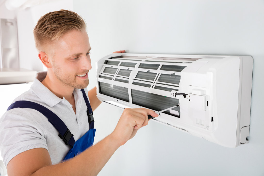 HVAC technician cleaning and repairing a ductless mini split AC in Scottsdale, AZ