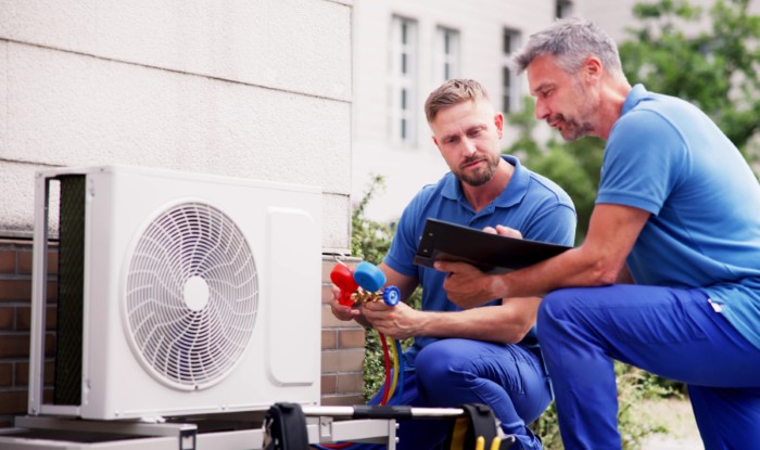 HVAC technicians reviewing an outdoor air conditioning unit in Scottsdale, AZ