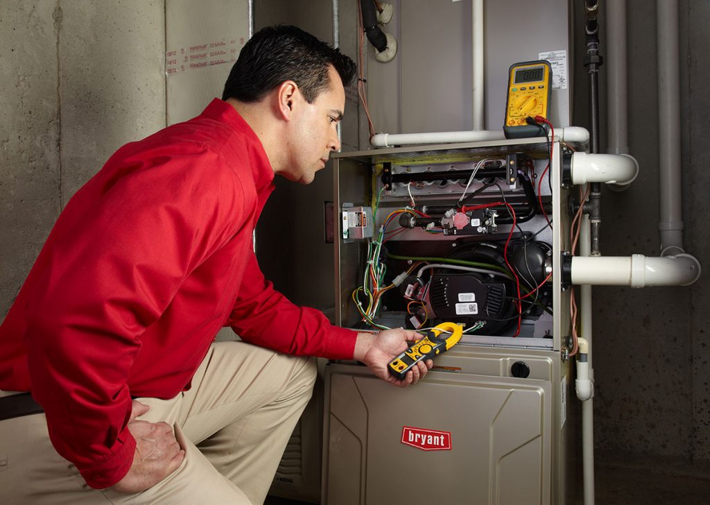 Heating and air conditioning technician servicing an indoor furnace in Scottsdale, AZ