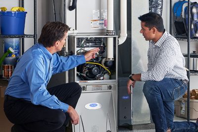 65df8c11f3e4c468cbd351a5_furnace repair vs replacement – Copy HVAC technician explaining furnace repair and maintenance to a homeowner in Scottsdale, AZ