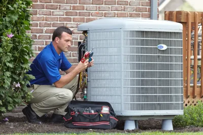 design-air-heating-and-air-conditioning-decatur-il-05 – Copy HVAC technician inspecting an outdoor air conditioning unit in Scottsdale, AZ