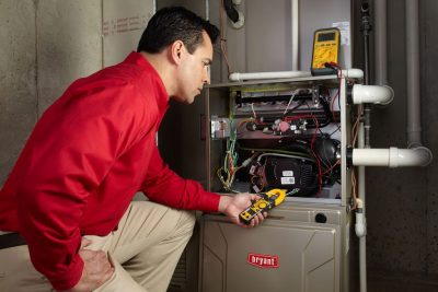 furnace repair Heating and air conditioning technician servicing an indoor furnace in Scottsdale, AZ